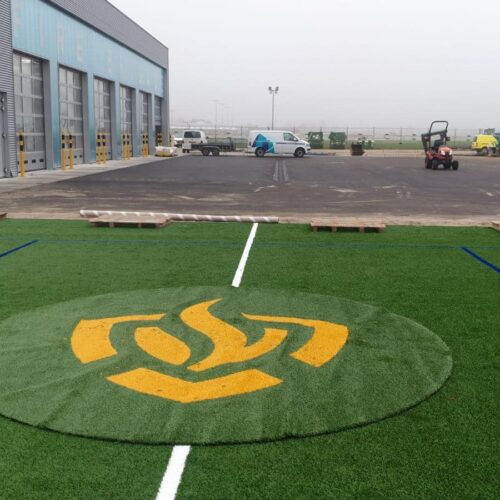Kunstgras speelvloeren 85 Aanleg van een grote voetbalkooi met LSR24mm kunstgras met een ingelegd logo. Locatie Rotterdam met het logo van de brandweer (airport)